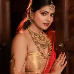 This portrait focuses on a direct, captivating gaze. The warm, directional lighting highlights the intricate details of the antique jewelry and the texture of the golden blouse, creating a powerful and intimate feel.