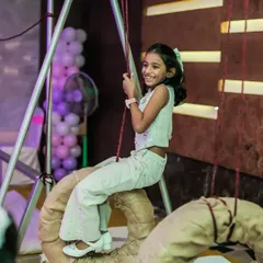 A young girl with a huge smile on her face as she enjoys the tire swing. Her happiness is the ultimate goal of every party I plan.