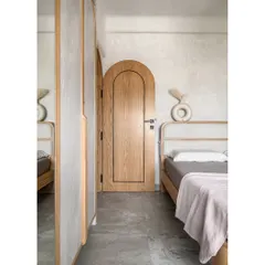 This bedroom is a perfect example of the calm and serenity I strive for with Japandi design. The arched door opens into a zen-like space with a custom fabric-padded bed and warm oak wood. By keeping the material palette minimal and focusing on texture and light, I created a peaceful retreat from the bustle of city life.