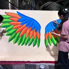 Here you can see my team and I painting the layers of feathers on the large-scale angel wings. Each colour is carefully chosen to create a vibrant gradient effect.