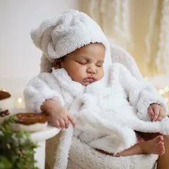 A cozy and cute setup for a sleeping newborn. Dressed in a tiny, fluffy bathrobe and cap, this baby is completely relaxed. I ensure the studio is warm and comfortable to keep newborns happy and sleepy.