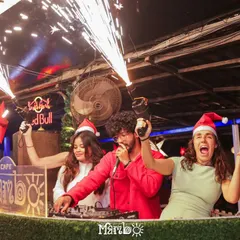 A Christmas party at Cafe Mambo with guests joining me at the booth, complete with Santa hats and sparklers. I love creating a festive and interactive atmosphere for special occasions.