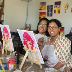 A mother and daughter duo all smiles during a painting session. Creating art together is a wonderful way to spend quality time as a family.
