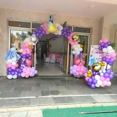 A magical entrance for a Disney Princess party. This balloon arch in purple, pink, and white is decorated with cutouts of Snow White and Cinderella's carriage.