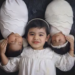 Three souls, one heart. ❤️ An older sister so proud of her new twin siblings. Sibling photos with newborns are so precious, and this overhead shot in classic white is just filled with so much love.