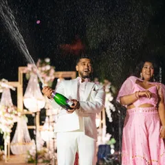 The champagne spray captures the excitement and joy of the couple's cocktail night celebration.