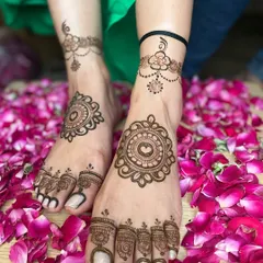 A simple and elegant foot mehandi design, perfect for a beach wedding or a party. The design features a central mandala and a delicate floral anklet.