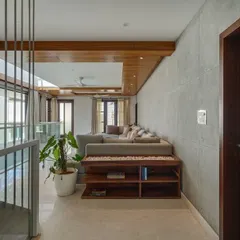 This cozy family space in 'Wilasa' is located on an upper floor, connecting the bedrooms. The material palette of wood, concrete, and soft textiles creates a warm and modern relaxation area.