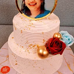 Make your celebration truly personal with a custom photo cake. This two-tier cake for a 50th birthday features an edible photo topper, elegant gold splatter, and floral accents, creating a beautiful and memorable tribute.