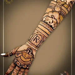 A personalized back-hand design featuring the initial 'R'. The arm is adorned with elephants and palace motifs, creating a full bridal look.