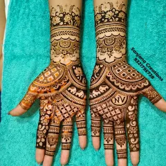 A complete view of a stunning bridal mehndi. Notice how the designs on both hands are unique yet complement each other perfectly, featuring elephants and personalised initials.