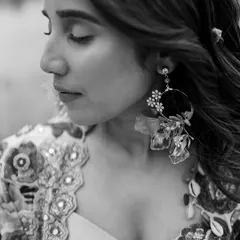 A close-up on the exquisite details. The floral embroidery on the jacket and the custom-made floral earrings were carefully selected to create a cohesive and artistic look.