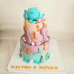 A magical two-tier sea themed cake for twins celebrating their first birthday. I loved creating the pastel colors and the little octopus, seahorses, and mermaid tails.
