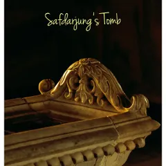 A close-up shot of the ornate marble carving on top of the cenotaph inside Safdarjung's Tomb. The elegant calligraphy and soft lighting highlight the delicate craftsmanship.
