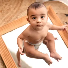 Who is that handsome baby in the mirror? Using props like mirrors is a great way to engage babies and capture their curious expressions as they discover their own reflection.