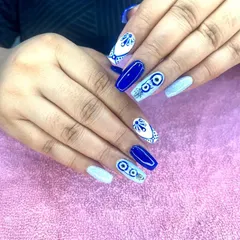 A striking evil eye design in royal blue and white. I combine the popular motif with other patterns for a unique, protective manicure.