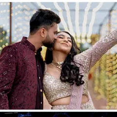 A happy couple enjoying their Sangeet party. The background of cascading fairy lights provides a perfect, sparkling setting for photos.