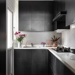 The compact, modern kitchen in the 'Rustic Minimal' apartment. We used sleek, dark cabinetry and a simple layout to maximize functionality without sacrificing style, ensuring the space feels clean and uncluttered.