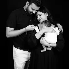 A bond beyond words. This black and white portrait of a new family is filled with emotion, capturing the love and awe as they hold their newborn baby.