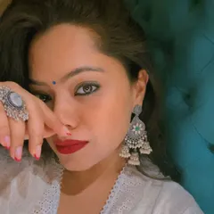 A close-up highlighting the power of accessorizing. The silver jewelry, bindi, and bold red lip complete this look, adding personality and strength to the traditional attire.