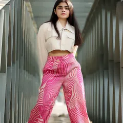 A strong, symmetrical fashion pose on a metal bridge. The leading lines of the bridge draw the eye to the model, while the vibrant patterned pants provide a pop of color.