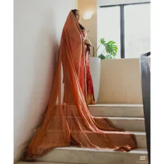 The flowing red and gold organza veil added a touch of modern drama to the bride's traditional Kanjeevaram saree, creating a beautiful silhouette as she walked.