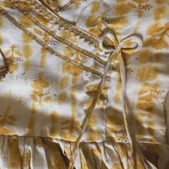 The beautiful tie-front detail of our yellow angarkha. This traditional closure is not only beautiful but also allows for an adjustable and comfortable fit.