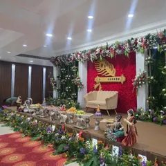 An angled shot of the Krishna flute stage, highlighting the surrounding greenery and offering table.