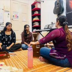 Our Hindustani vocal course creates a traditional and focused learning environment. Here, students are seated on the floor, fully immersed in a lesson with their coach, learning the nuances of Indian classical vocal techniques.
