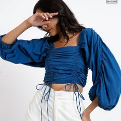 A close-up detail shot that highlights the ruching and tie-strings on the blue top, an important feature for online shoppers.