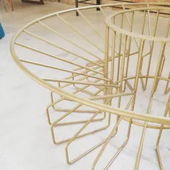 A detail shot of the finished Bloom table base, showing the graceful curves and clean weld joints. The gold powder coating gives it a durable and luxurious finish.