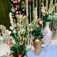 A close-up of the elegant floral arrangements I create. This bouquet features white tuberoses and pink roses, placed in decorative vases to enhance the stage decor.