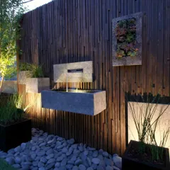 This design shows how a water feature can be part of a larger artistic wall composition. I installed a modern, floating fountain and matching planters on a dark, textured wood wall, creating a unique and stylish focal point.