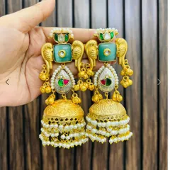 Statement earrings featuring a parrot motif in gold, with green stones and layered jhumka drops. These are a playful yet traditional accessory.