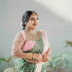 Our client looks absolutely radiant in a green and pink half-saree. Her joyful smile is the best accessory to the custom-embroidered pink blouse and traditionally printed green skirt, perfect for a festive family occasion.