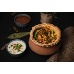 A clay pot of handi biryani, styled with raita and salan against a dark, textured background. The use of traditional serving ware and spices like cinnamon and bay leaf enhances the authentic appeal.