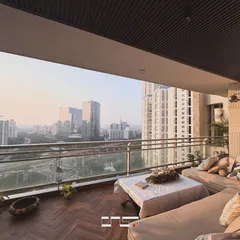 A stunning view over the city from the balcony lounge. The comfortable sofa is perfect for relaxing and taking in the expansive urban landscape.