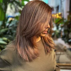 A side profile showing how the light hits this mahogany balayage. The layers and color work together to create a dynamic and face-framing effect.
