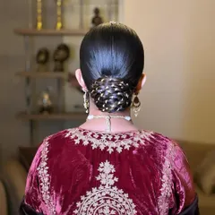 A traditional and elegant 'Gotta Bun'. I've woven golden 'gotta' or ribbon through the twists of this sleek bun, which is a classic choice for brides wearing traditional velvet or silk outfits.