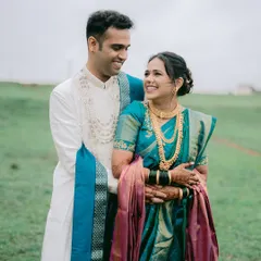 The vibrant colors of a traditional Paithani saree against a lush green field. This portrait from a pre-wedding shoot near Pune showcases the elegance of Maharashtrian attire in a natural, open setting.