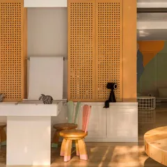 I designed these custom bunny-eared stools to bring a sense of fun and whimsy to the space. Paired with perforated wood panels and a paper roll for drawing, this corner is all about encouraging creativity.