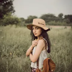 A soft, moody portrait taken in a field, giving it a vintage and timeless feel. This kind of lifestyle photography is about capturing a feeling and a quiet moment in nature.
