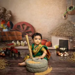 Here, she is using a traditional stone grinder prop, adding a touch of authenticity to this Maharashtrian themed baby shoot.