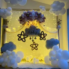 We brought a dreamy sky indoors for this baby shower. The setup features fluffy white balloon clouds, a warm backdrop of fairy lights, and a central balloon arrangement in pink and gold, creating a magical and serene atmosphere for welcoming the little one.