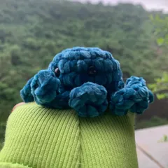 A side view of the velvet octopus amigurumi, showing off its curly tentacles. These plushies are great sensory toys or just cute desk buddies.