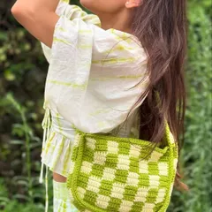 A candid shot of our checkered crochet shoulder bag being worn. This view highlights its comfortable size and how it sits perfectly as a stylish, everyday accessory.
