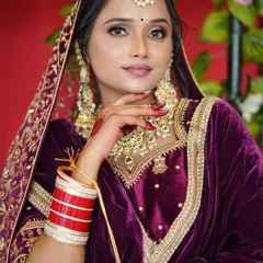 For this stunning North Indian bride, we created a glamorous look with bold, smoky eyes and a matte pink lip to complement her rich purple velvet lehenga. The heavy Kundan jewelry, chooda, and maang tikka complete this regal bridal ensemble.