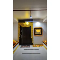 A traditional and welcoming entrance for a home ceremony, adorned with beautiful marigold torans and garlands.