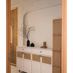 The foyer sets the tone for the home with micro-topped walls and custom furniture. The tall oakwood unit with cane laminate and chamfered details provides practical storage for sports gear.