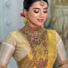 Another angle of this stunning golden bridal look, showcasing the flawless skin finish and the intricate details of the temple jewelry.